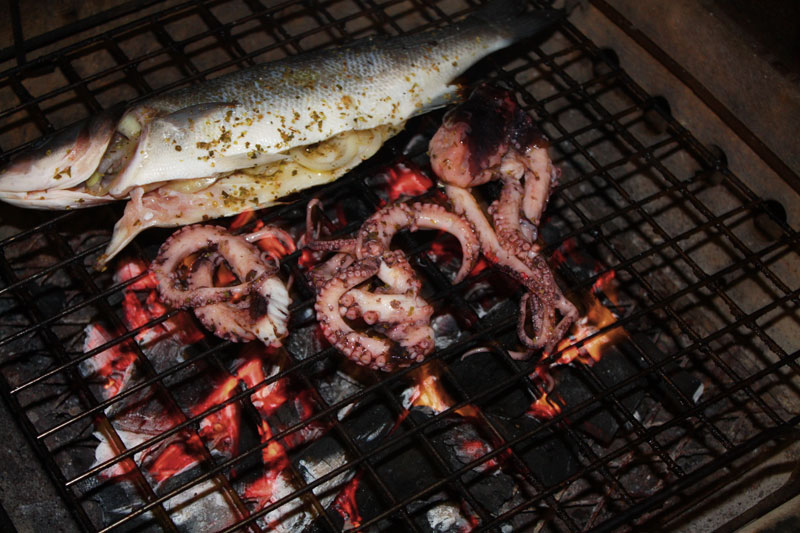 Grilling octopus at home over a chargoal grill